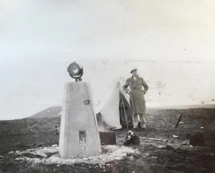 Historic photo of a surveyor, their tent, and the beacons used.